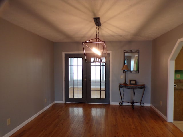 unfurnished dining area featuring french doors and dark hardwood / wood-style floors