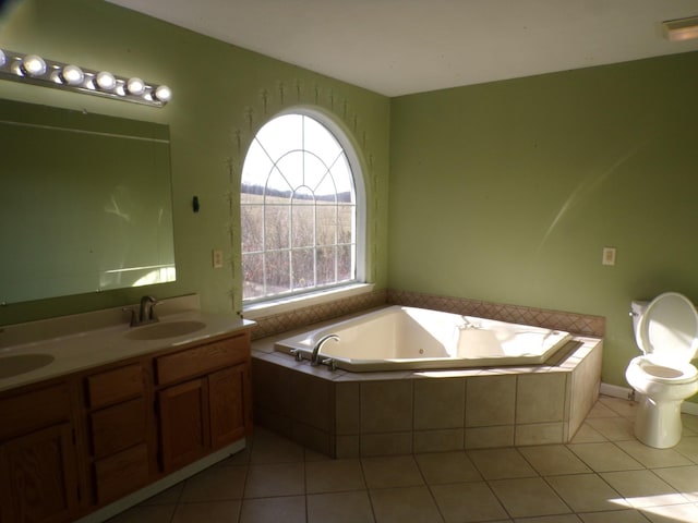 bathroom featuring tiled bath, tile patterned floors, toilet, and vanity