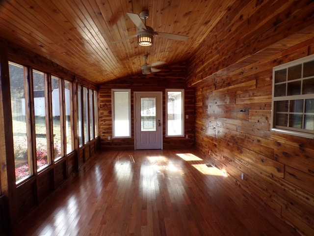 interior space featuring lofted ceiling, dark hardwood / wood-style flooring, wood walls, wooden ceiling, and ceiling fan