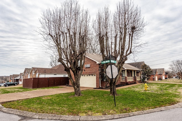 view of front of home featuring a porch, brick siding, fence, driveway, and a front lawn