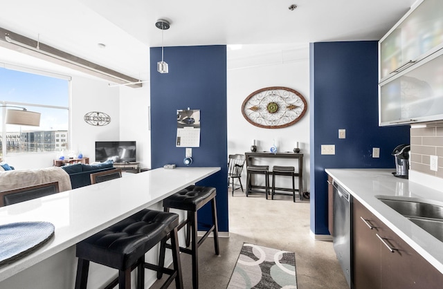 kitchen with a breakfast bar, dishwasher, tasteful backsplash, and decorative light fixtures