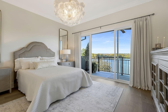 bedroom featuring a notable chandelier, a water view, light wood-type flooring, access to outside, and ornamental molding