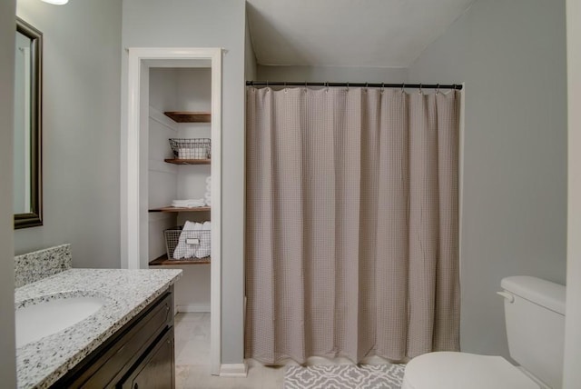 bathroom with toilet, a shower with shower curtain, and vanity