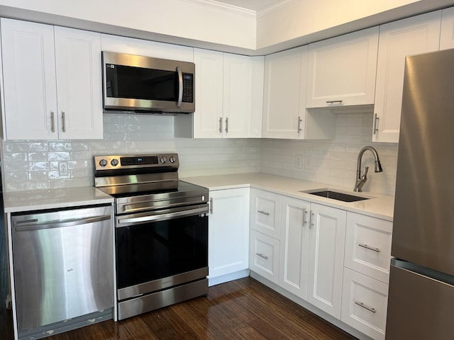 kitchen featuring sink, white cabinetry, crown molding, stainless steel appliances, and dark hardwood / wood-style flooring