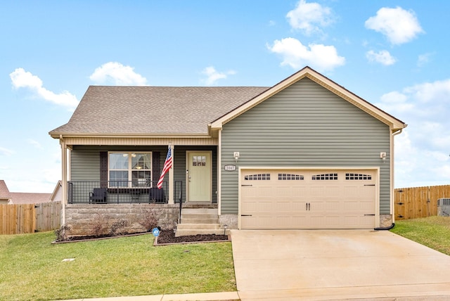 view of front of house featuring covered porch, a garage, and a front lawn