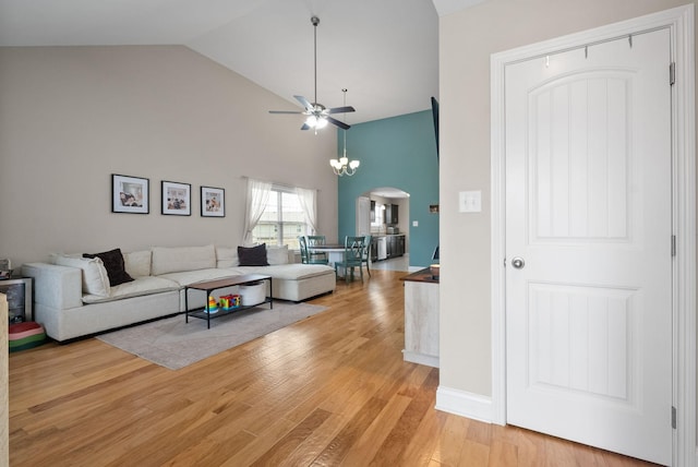 living room featuring ceiling fan with notable chandelier, high vaulted ceiling, and wood-type flooring