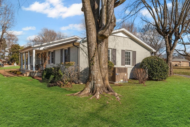 view of side of home with a yard