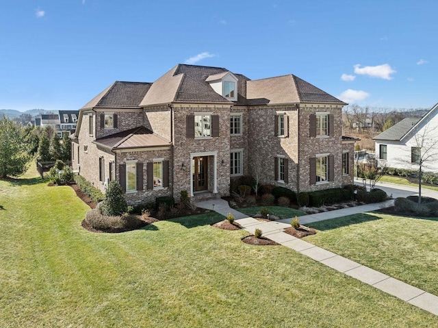 view of front of house featuring brick siding and a front yard