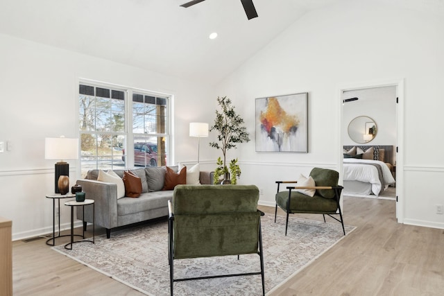 living room with high vaulted ceiling, light wood-type flooring, a ceiling fan, and baseboards