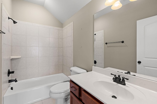 full bathroom featuring tile patterned floors, toilet, vaulted ceiling, tiled shower / bath, and vanity