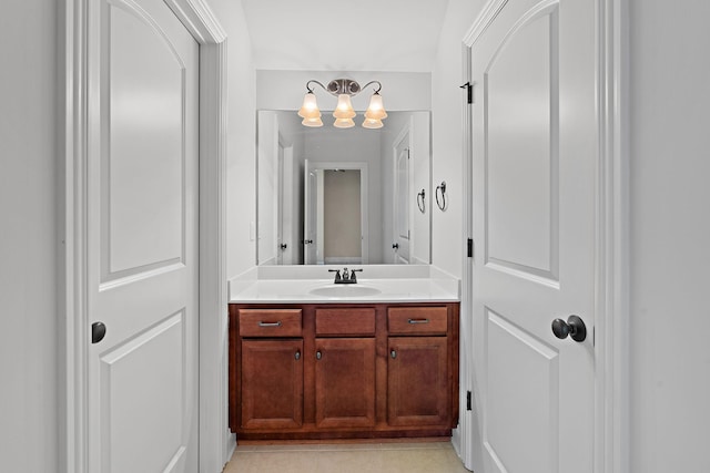 bathroom featuring a notable chandelier, vanity, and tile patterned floors