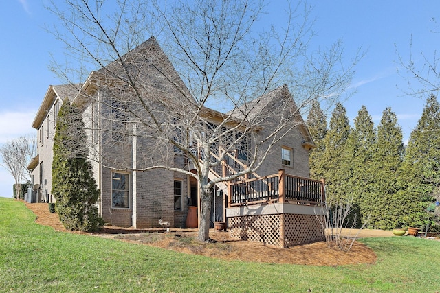 rear view of house featuring a yard and a wooden deck