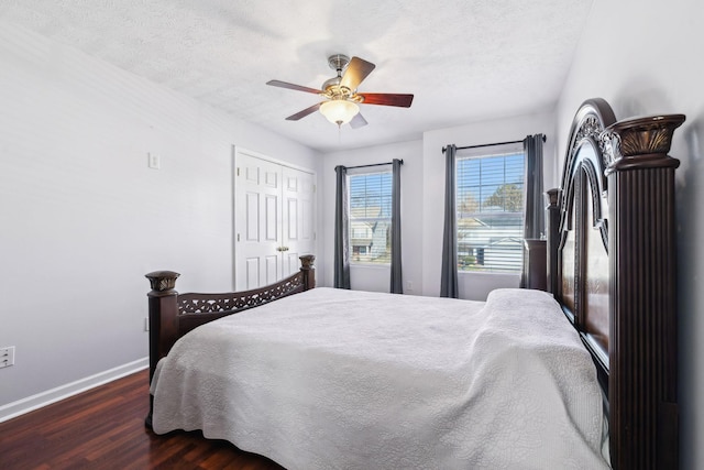 bedroom featuring dark hardwood / wood-style flooring, ceiling fan, a textured ceiling, and a closet