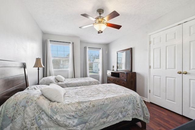 bedroom with dark hardwood / wood-style flooring, ceiling fan, and a textured ceiling