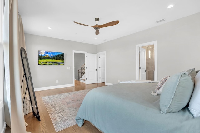 bedroom featuring ceiling fan, light wood-type flooring, and connected bathroom