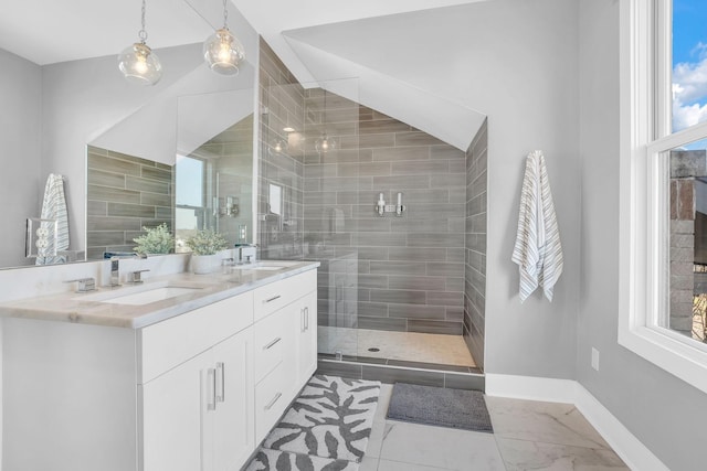 bathroom with a tile shower and vanity