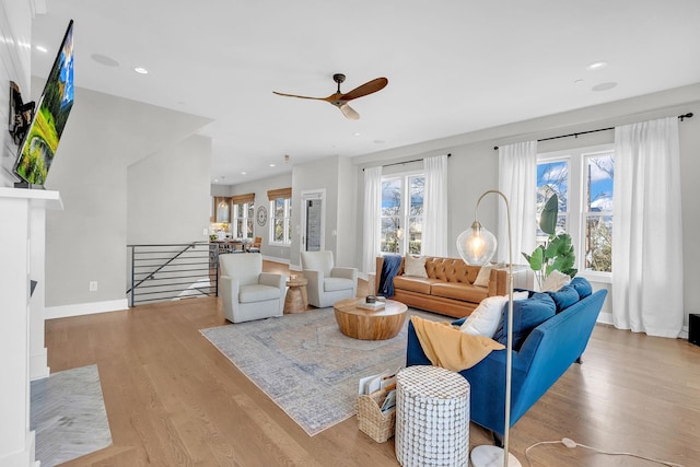 living room with ceiling fan and light wood-type flooring