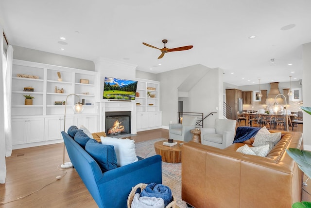 living room with light hardwood / wood-style floors and ceiling fan