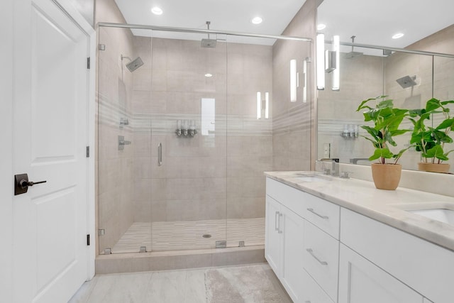 bathroom with vanity and a shower with door