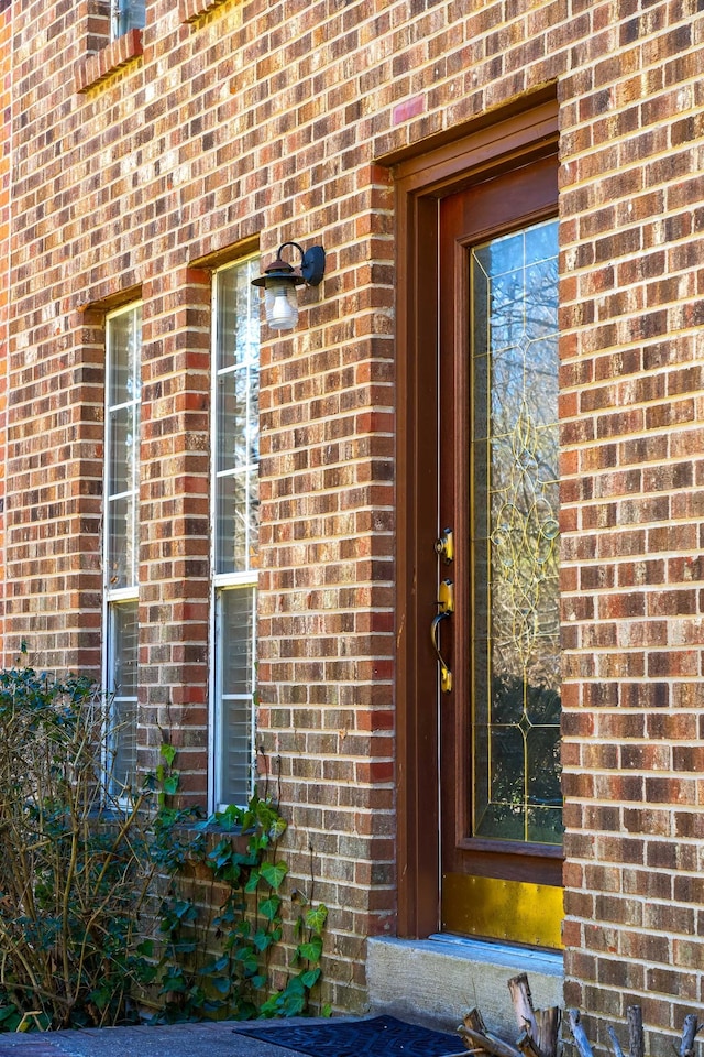 view of exterior entry featuring brick siding