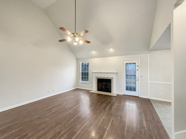 unfurnished living room with dark wood-type flooring, high vaulted ceiling, and ceiling fan