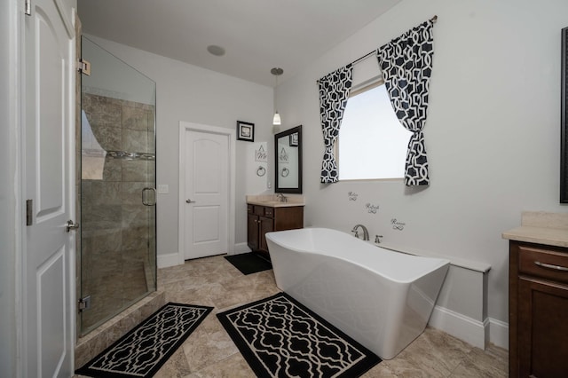 bathroom featuring a freestanding bath, a stall shower, vanity, and baseboards