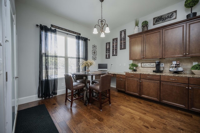 dining room with an inviting chandelier, baseboards, and dark wood-type flooring