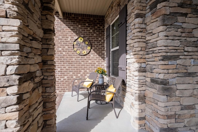 exterior space with stone siding, brick siding, and a porch