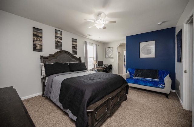 bedroom with arched walkways, light colored carpet, a ceiling fan, baseboards, and visible vents