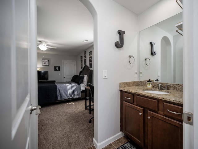 bathroom featuring ceiling fan, baseboards, and vanity