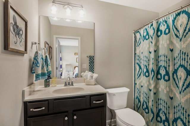 bathroom featuring toilet, vanity, and walk in shower