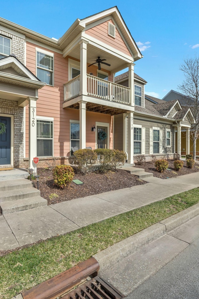 view of front of house with ceiling fan and a balcony