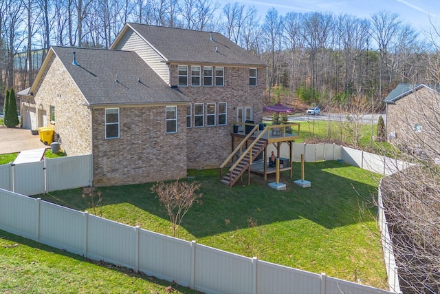 7144 Triple Crown Ln, Fairview, TN 37062 - back of property with a fenced backyard, brick siding, stairs, a yard, and a wooden deck