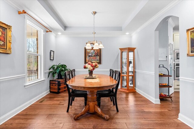 7144 Triple Crown Ln, Fairview, TN 37062 - dining space featuring arched walkways, wood finished floors, a raised ceiling, and visible vents