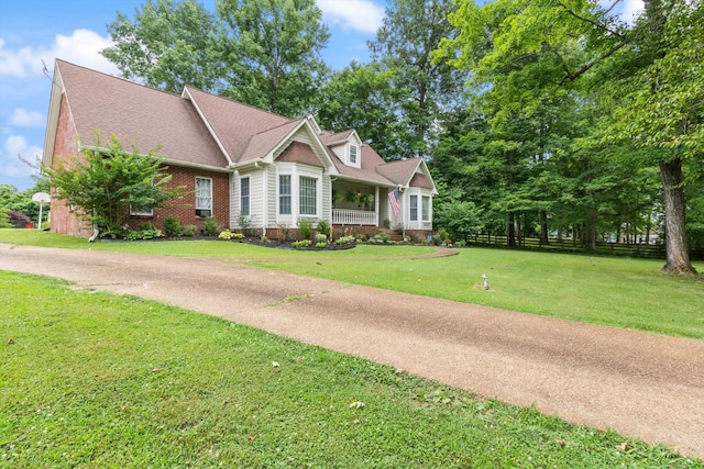 view of front of house featuring covered porch and a front yard