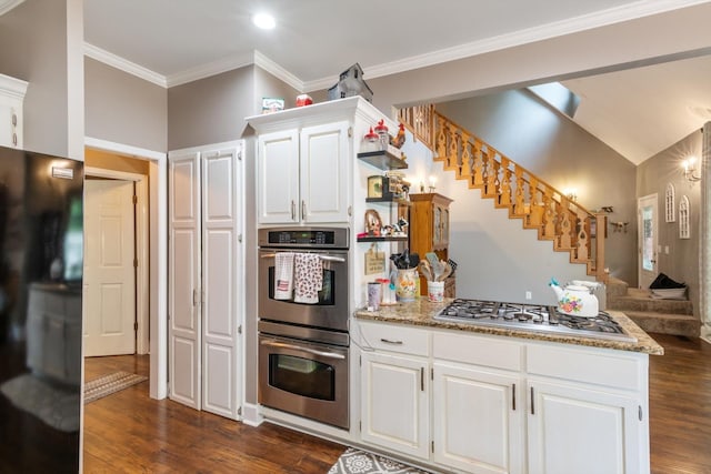 kitchen with white cabinetry, dark wood-type flooring, appliances with stainless steel finishes, and dark stone counters