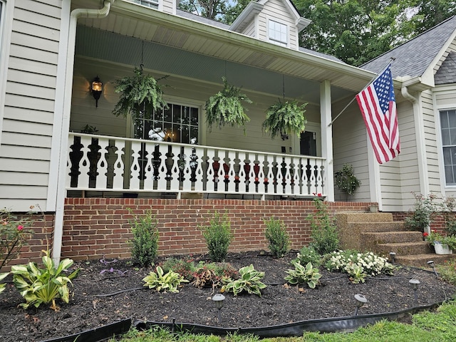 view of exterior entry featuring covered porch