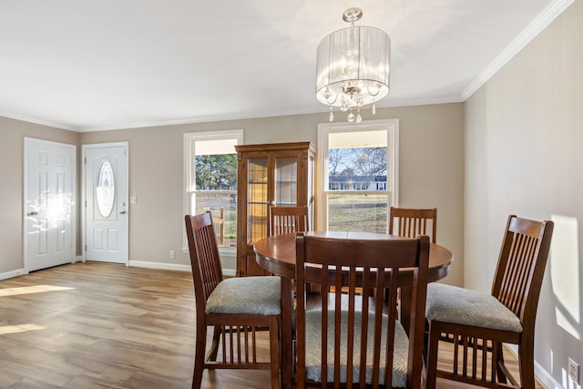 dining room with ornamental molding, an inviting chandelier, and hardwood / wood-style floors