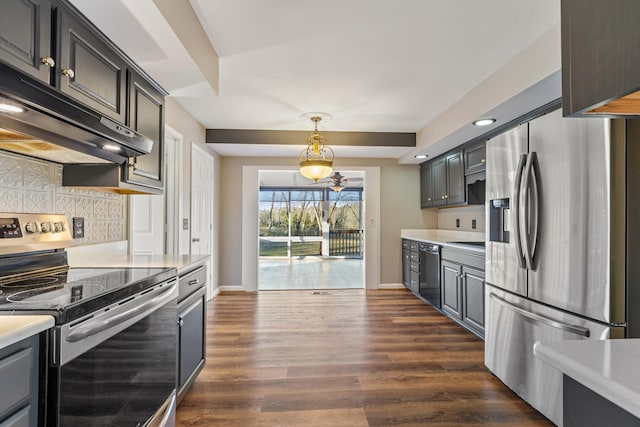 kitchen with appliances with stainless steel finishes, decorative light fixtures, tasteful backsplash, and dark hardwood / wood-style floors