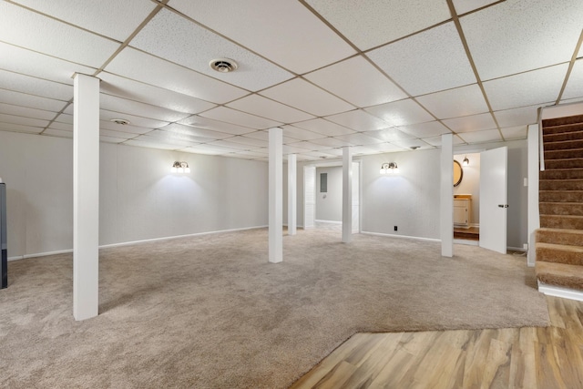 basement featuring wood-type flooring and a drop ceiling