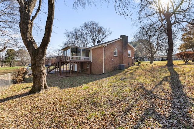 view of home's exterior featuring cooling unit, a wooden deck, a sunroom, and a lawn