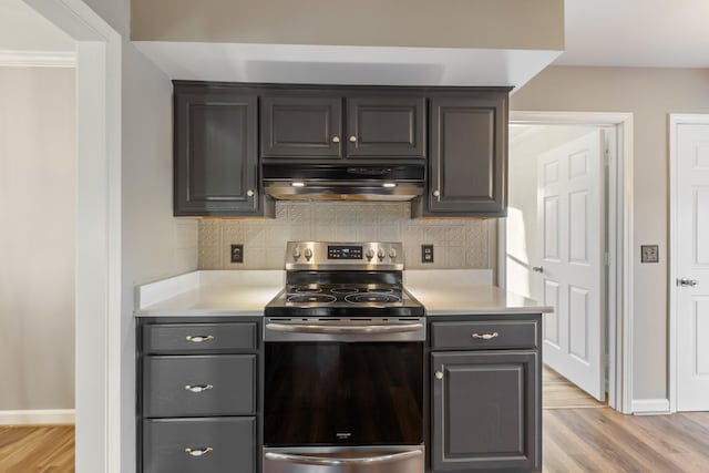 kitchen with light hardwood / wood-style floors, electric stove, range hood, and decorative backsplash