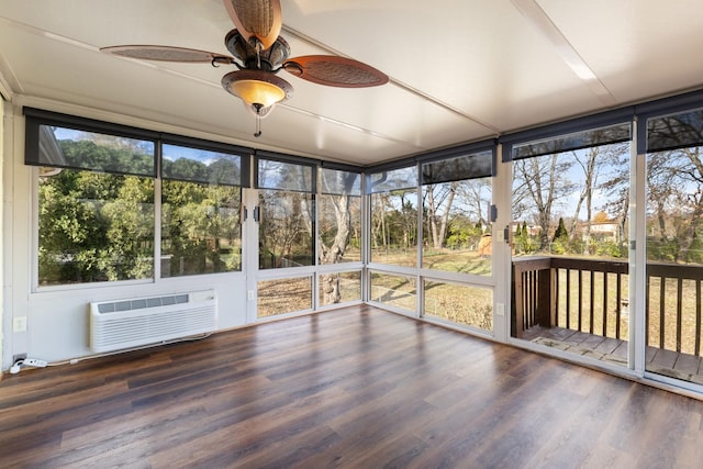 unfurnished sunroom with ceiling fan and a wall unit AC