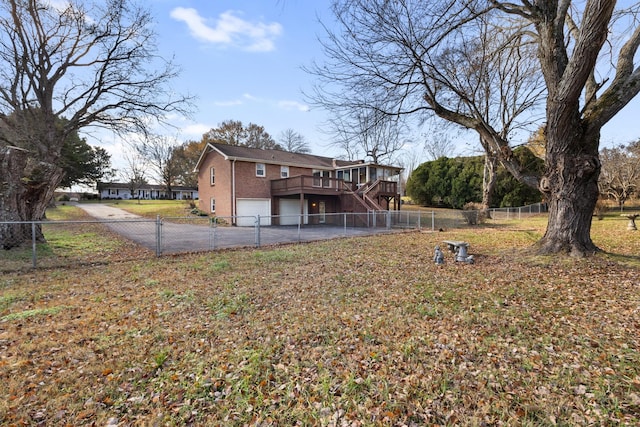 back of house with a deck, a garage, and a lawn