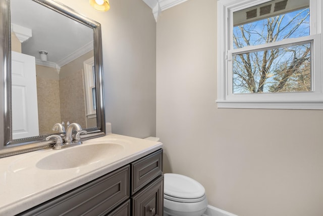 bathroom with vanity, crown molding, and toilet