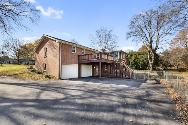 back of property with a garage and a deck