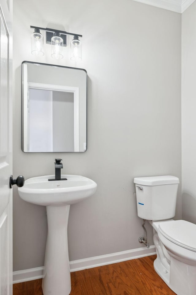 bathroom with baseboards, toilet, and wood finished floors