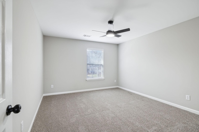 carpeted empty room with visible vents, ceiling fan, and baseboards