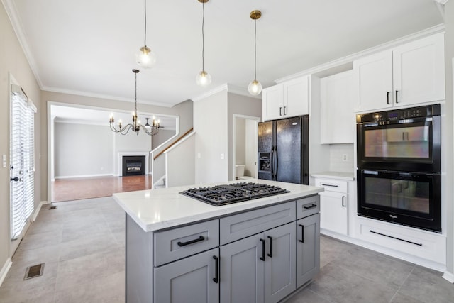 kitchen with hanging light fixtures, black appliances, white cabinets, and gray cabinetry