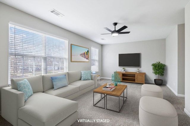 living area with carpet, baseboards, visible vents, and a ceiling fan